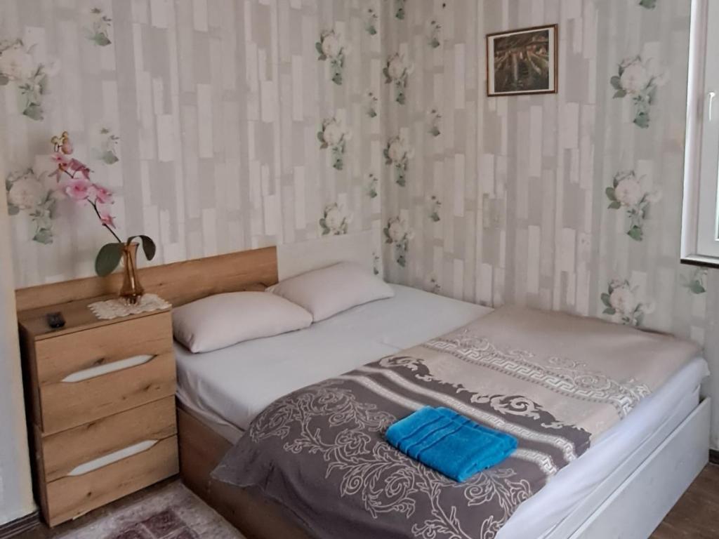 a small bedroom with a bed and a dresser at Guest House The House in Plovdiv