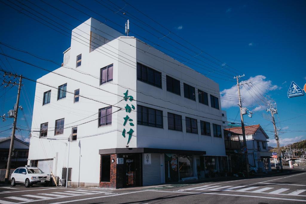 un edificio blanco con un cartel en el costado en Wakatake, en Katsuura