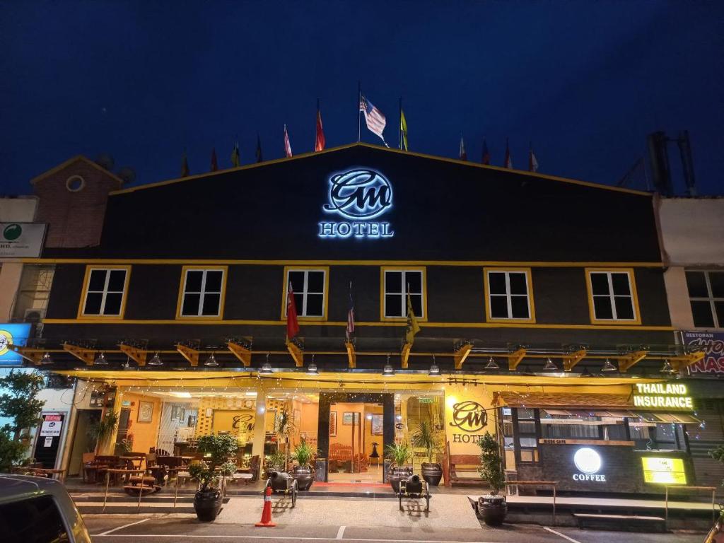 un hotel con un cartel en la parte delantera de la noche en GM Hotel, en Changlun
