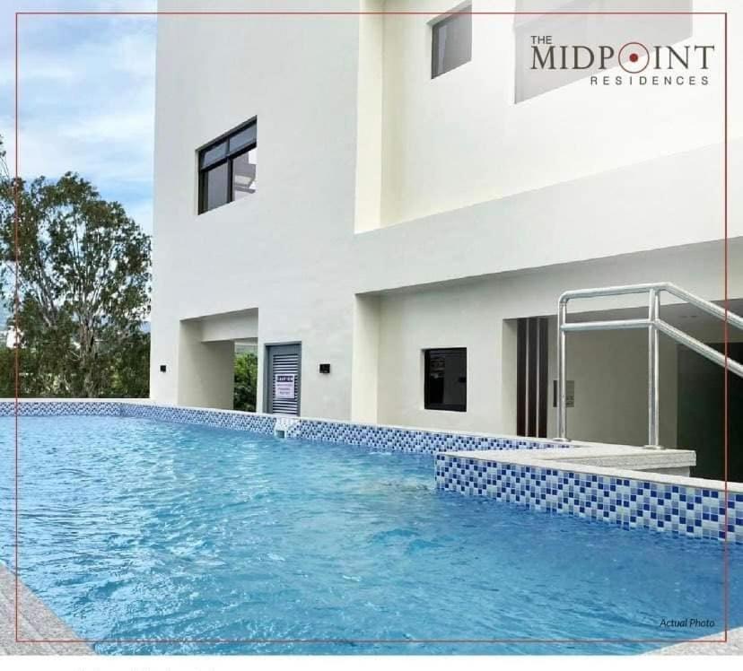 a large swimming pool in front of a building at The Midpoint Residences in Mandaue City