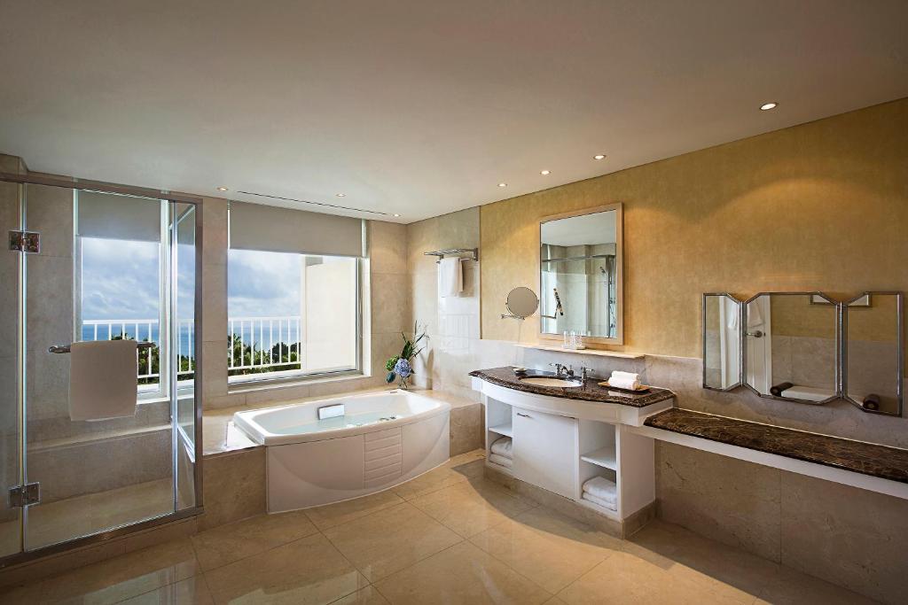 a bathroom with a tub and a sink and a shower at The Shilla Jeju in Seogwipo
