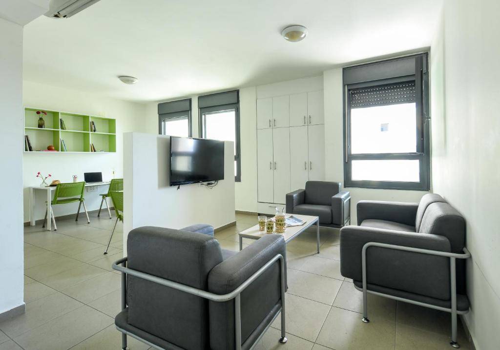TV a/nebo společenská místnost v ubytování דירות גני תערוכה - TLV university apartments near Expo by Sea N' Rent
