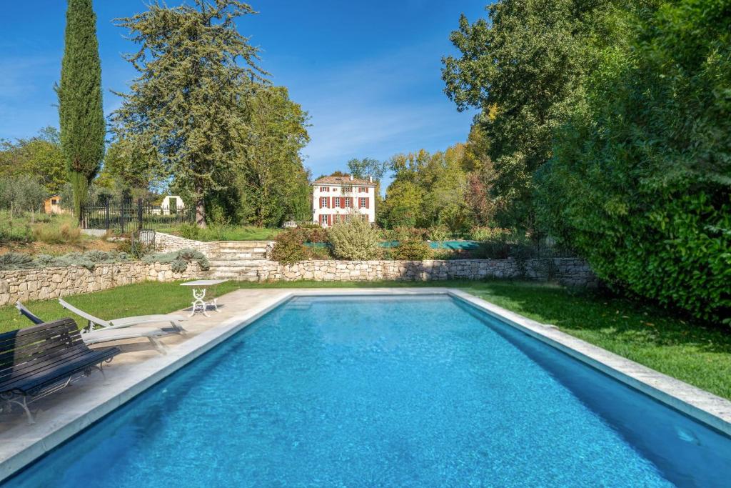 a swimming pool in a yard with a bench and a house at APPARTEMENT DERNIER ETAGE DANS BASTIDE in Aix-en-Provence