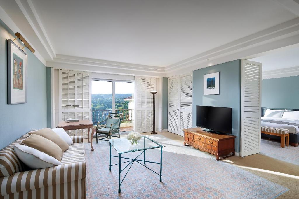 a living room with a couch and a tv and a bed at The Shilla Jeju in Seogwipo