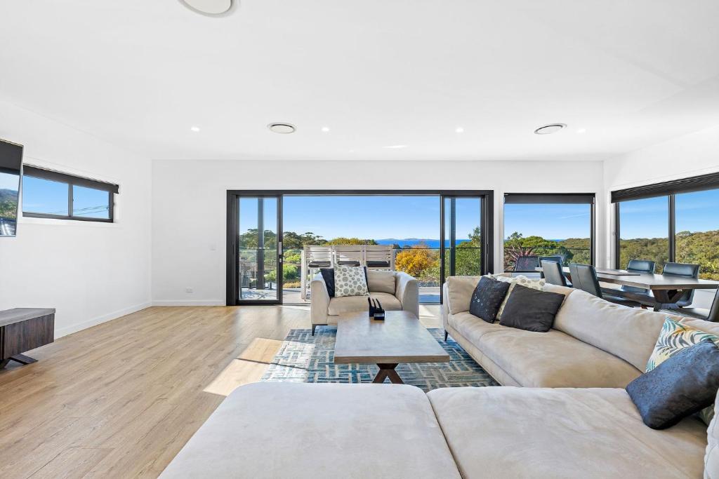 Montague Sunrise 2 Riley Street Narooma في ناروما: غرفة معيشة بها أريكة وطاولة