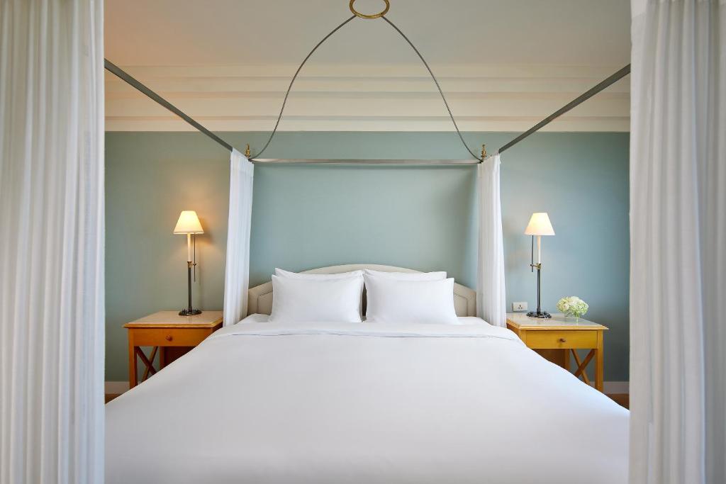 a bedroom with a large white bed with two lamps at The Shilla Jeju in Seogwipo