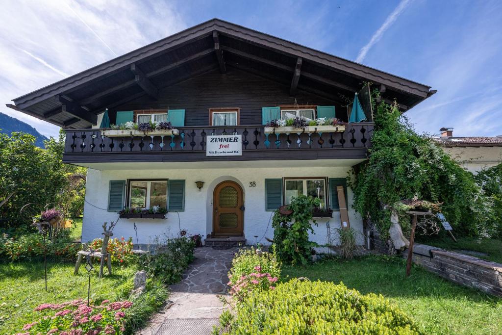 una casa con un balcón con un cartel. en Gästehaus Döring, en Mittenwald