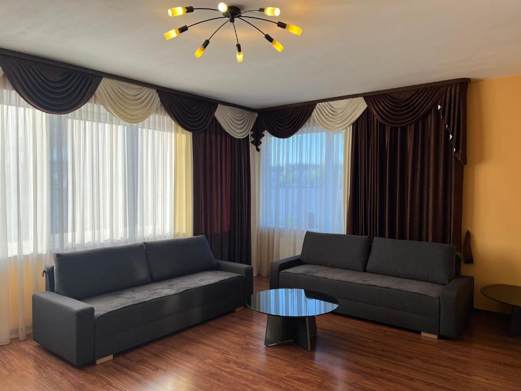 a living room with two couches and a table at Cat Garden Elegant Apartments Riga in Rīga