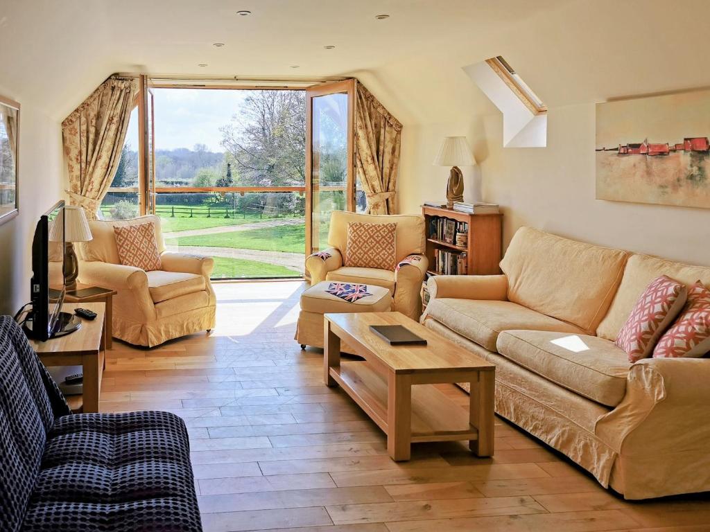 a living room with furniture and a large window at Green Acre Lodge in Tatterford