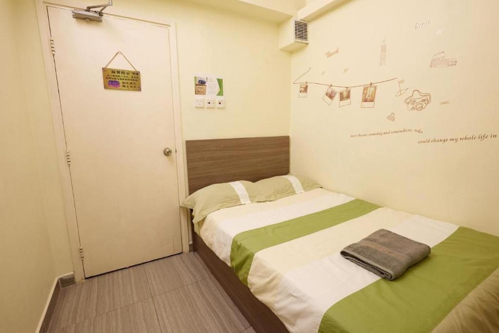 a small room with a bed and a door at Wai fan Guest house in Hong Kong