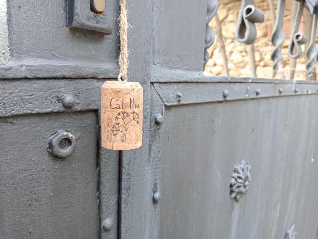 una puerta con una etiqueta de madera al lado de una puerta en Cal Niu, en Castillo de Aro