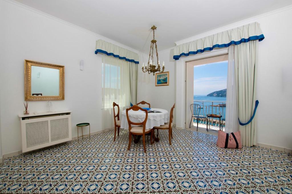 uma sala de jantar com uma mesa e vista para o oceano em Casa del Duca em Amalfi