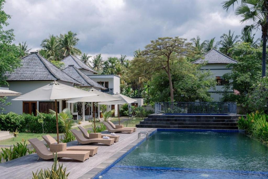 une villa avec une piscine et une maison dans l'établissement Ariana Beach Resort Amed Bali, à Amed