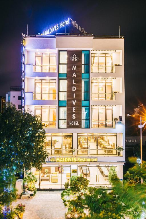 a large white building with a sign on it at Maldives Hotel - FLC Sầm Sơn in Sầm Sơn