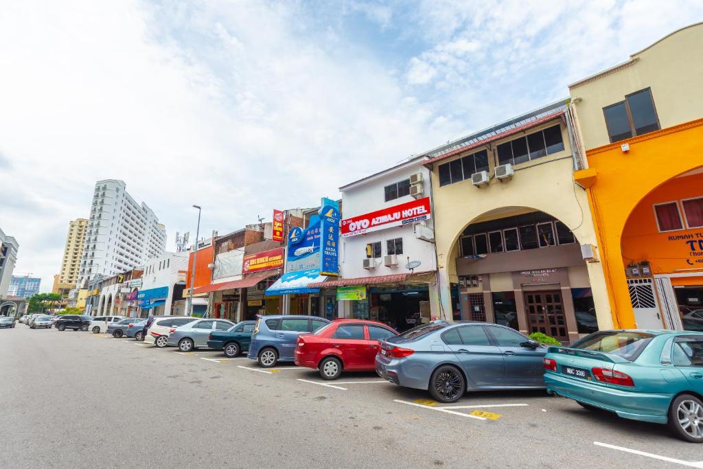una fila di auto parcheggiate sul lato di una strada cittadina di OYO 1132 Azimaju Guesthouse a Malacca