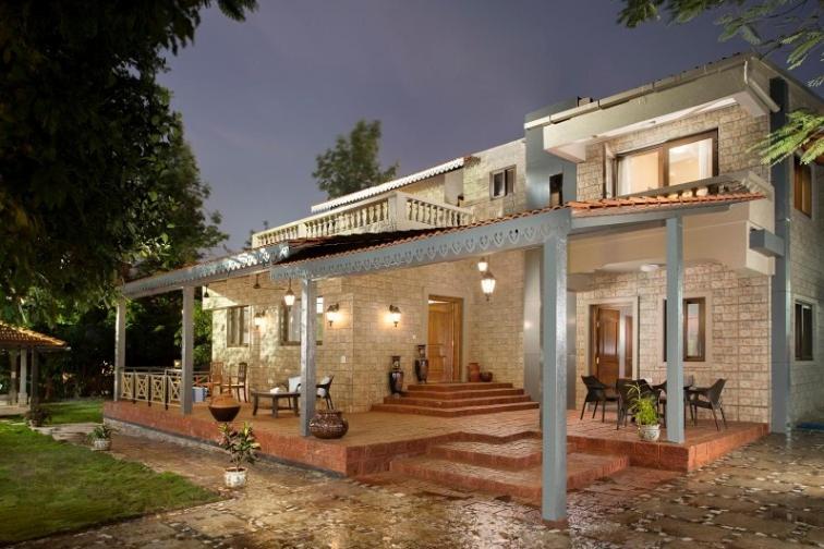 a large brick house with a porch and a deck at ama stays & trails - Dulwich Park View in Panchgani