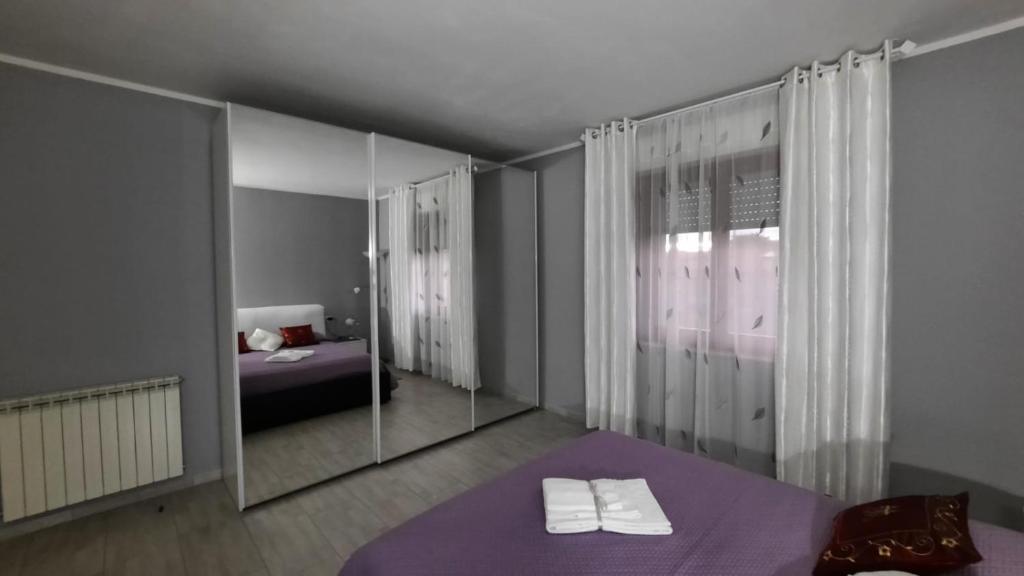 ein Schlafzimmer mit einem Spiegel und einem Bett darin in der Unterkunft Da Daniela in Castiglion Fiorentino