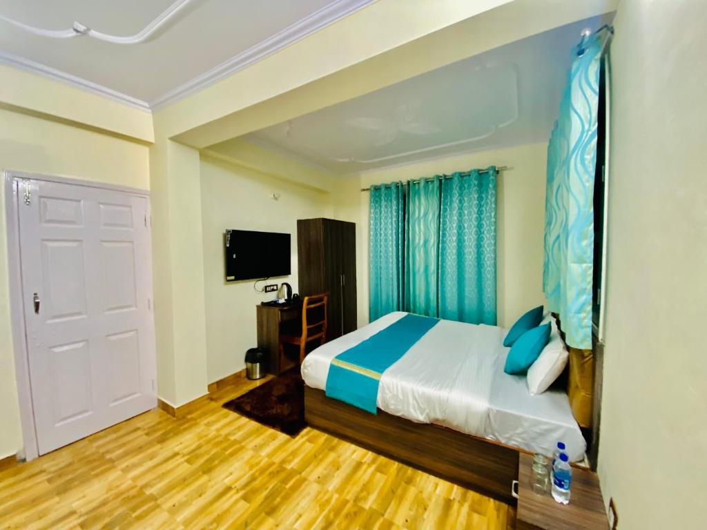 Habitación de hotel con cama y TV en Staynest Mashobra with balcony- A peacefull stay, en Shimla