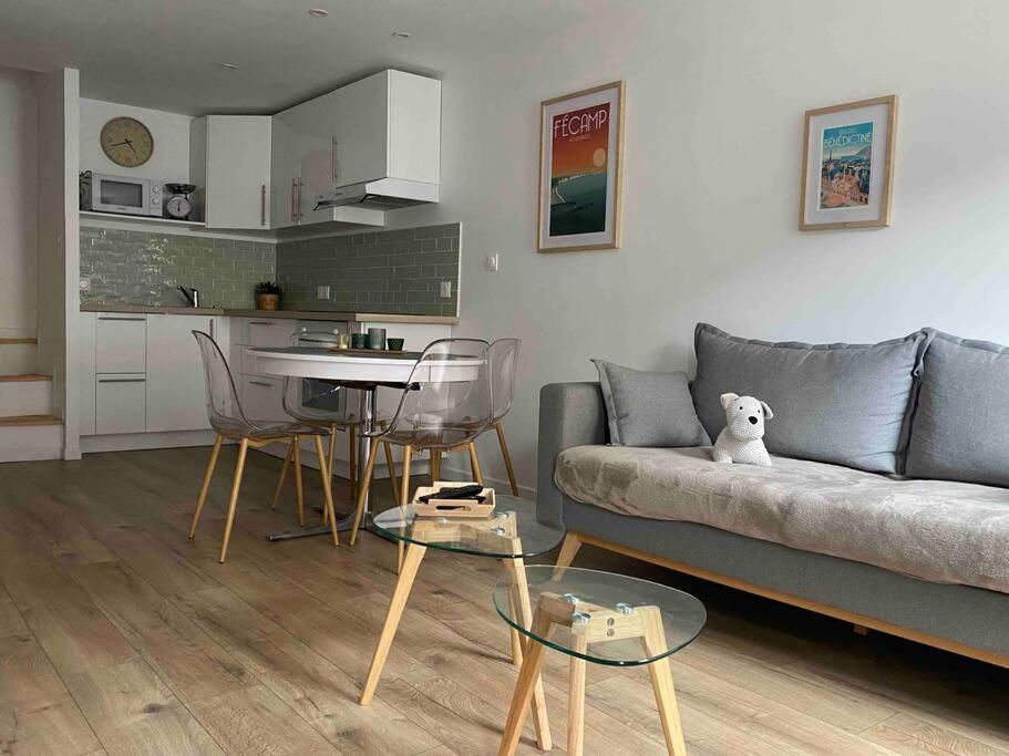 un salon avec un canapé et une table avec des chaises dans l'établissement La maison près du port, à Fécamp