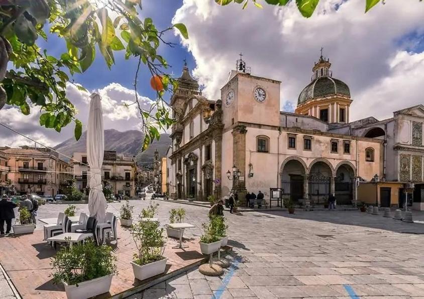 a large building with a clock tower in a courtyard at Il Moro in Carini