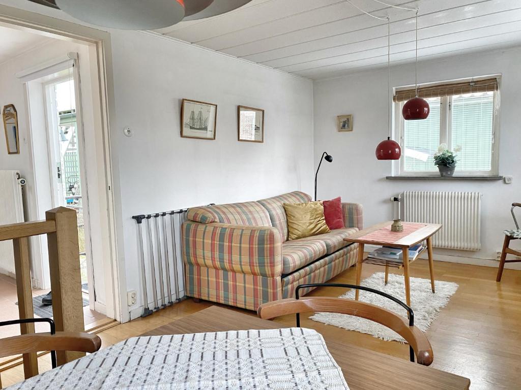 sala de estar con sofá y mesa en Retro cottage with garden in Torekov's best location, en Torekov