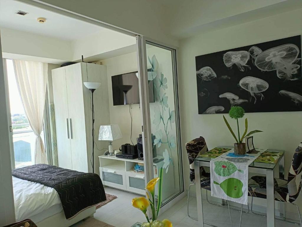 een slaapkamer met een spiegel, een bed en een tafel bij Azure Urban Resort Residences By April in Manilla