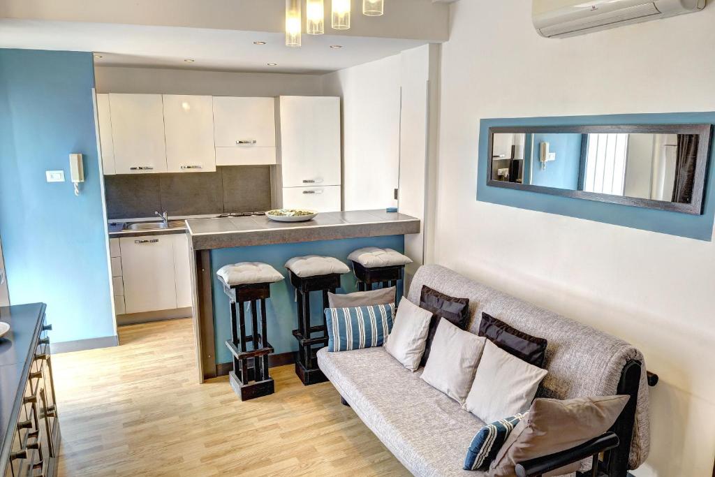 ein Wohnzimmer mit einem Sofa und einer Küche in der Unterkunft Eidos in Taormina