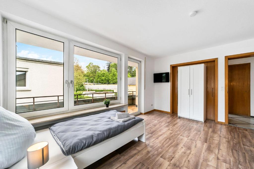 sypialnia z łóżkiem i dużymi oknami w obiekcie MONTEURWOHNUNG Göppingen GP04 RAUMSCHMIDE Apartments w mieście Göppingen