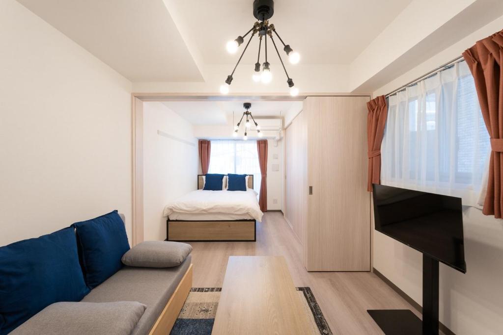 uma sala de estar com um sofá e uma cama em Casa Blan em Tóquio