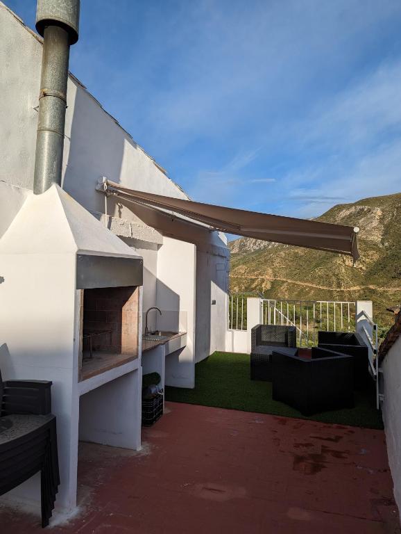 a white house with a patio with a fireplace at Entre montañas in Dos Aguas