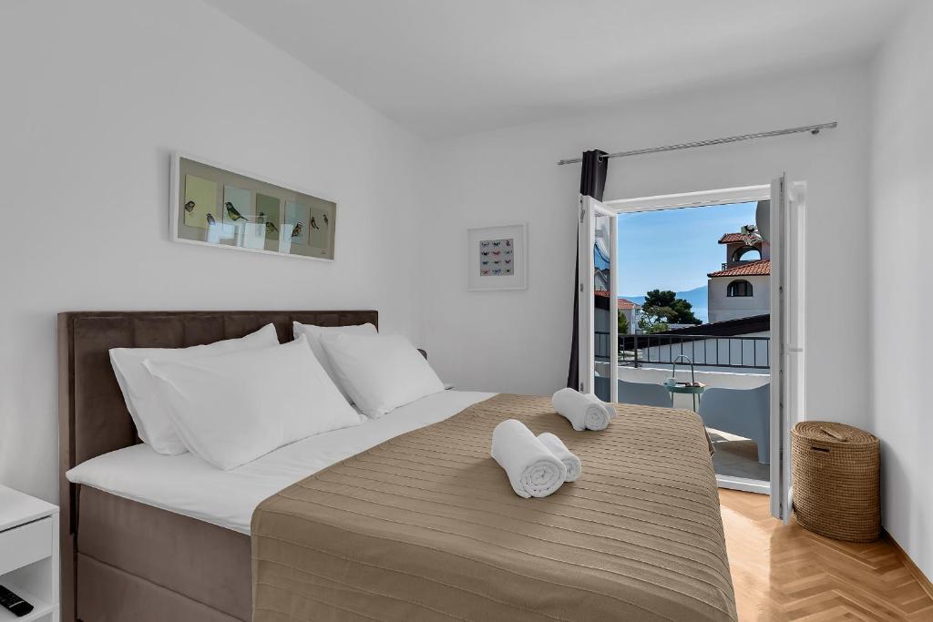 - une chambre avec un lit et des serviettes dans l'établissement Apartments Barbarić, à Zaostrog
