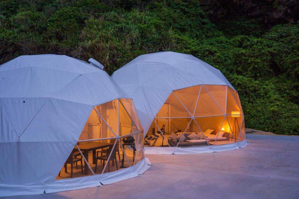 two white tents sitting next to each other at glampark resort Akuna beach in Henza