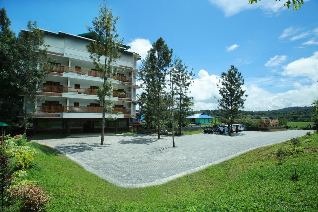 una vista de un edificio con árboles delante de él en ELEPHANT ROUTE, en Thekkady