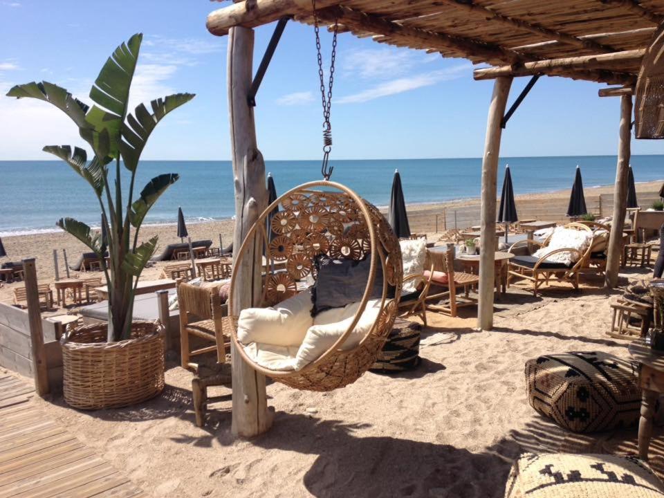 a swinging chair on a beach with the ocean at Havre de paix, jardin, place parking proche plage in Montpellier