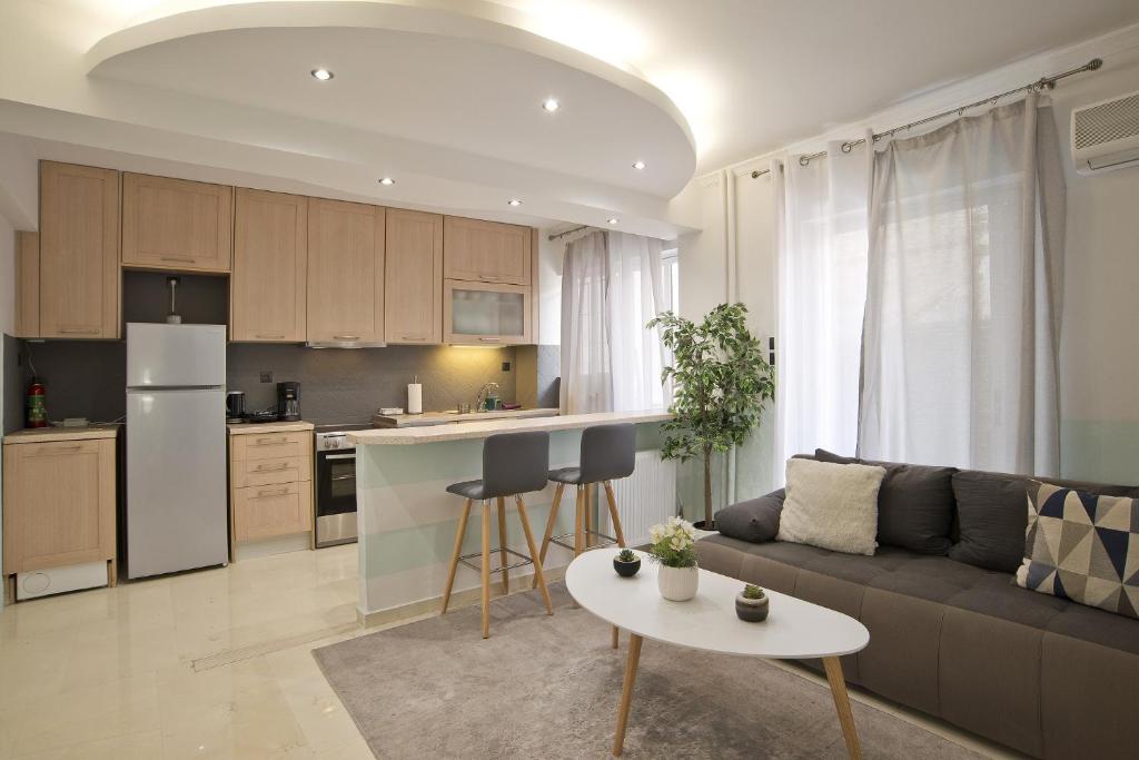een woonkamer en een keuken met een bank en een tafel bij Blue Dream in Piraeus