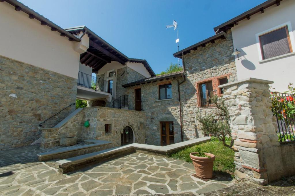 a stone house with a courtyard and a building at Ca' di Martino in Gavedo