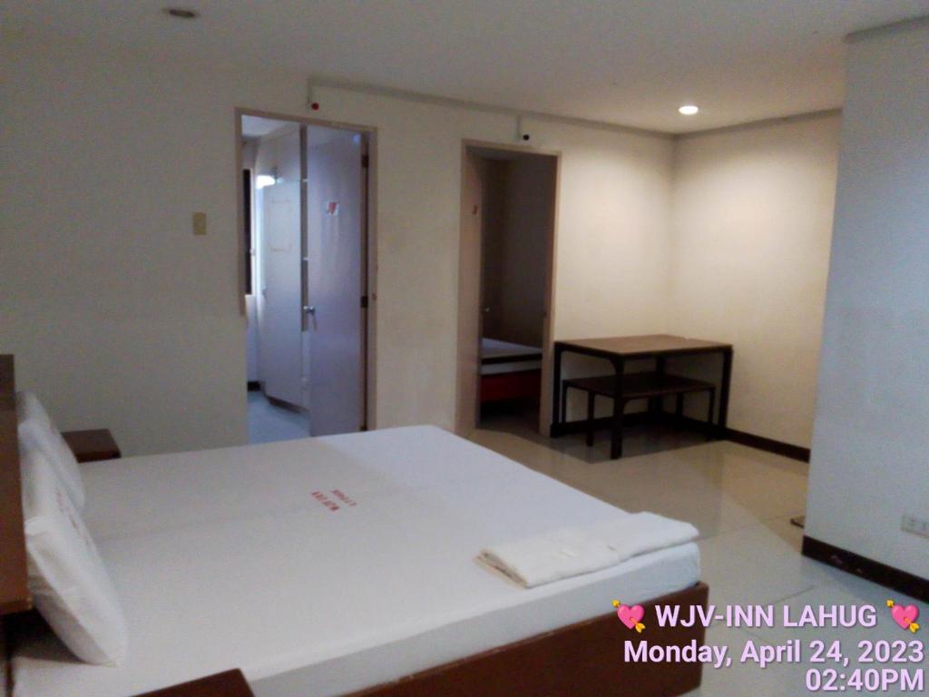 1 dormitorio con 1 cama y 1 mesa en una habitación en WJV INN LAHUG, en Cebú