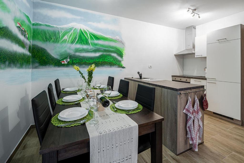 a dining room with a table and a kitchen at Apartmaji Koza in Zgornje Gorje
