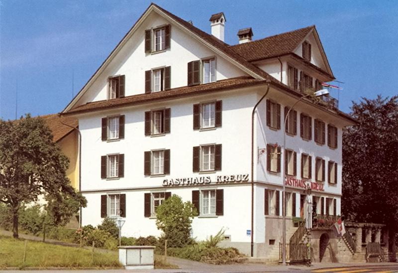 un gran edificio blanco con un cartel. en Gasthaus zum Kreuz en Lucerna