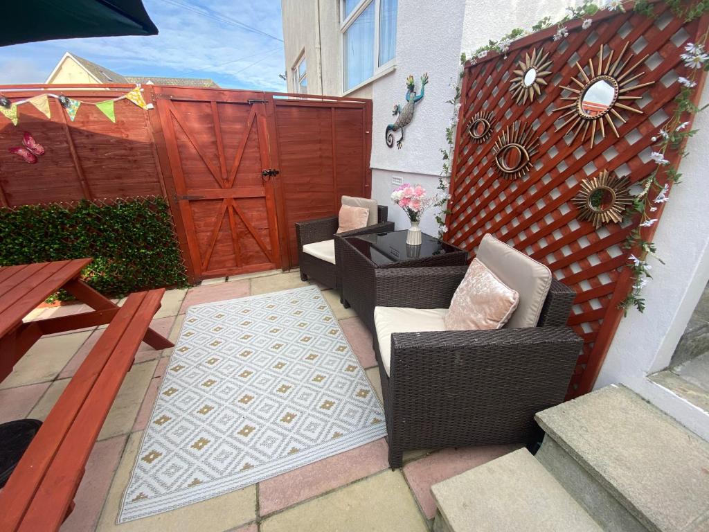 a patio with a gate and chairs and a table at The Garden Flat in Paignton