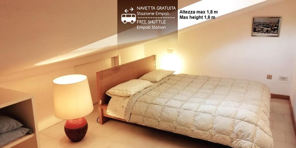 sypialnia z łóżkiem i lampką w obiekcie L'Alloggio di Anna Maria Mansarda con bagno privato w mieście Empoli