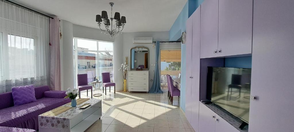 a living room with a purple couch and a tv at Mary's Apartment in Kos