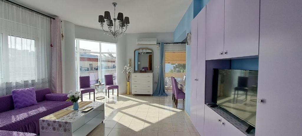 salon z fioletową kanapą i telewizorem w obiekcie Mary's Apartment w mieście Kos