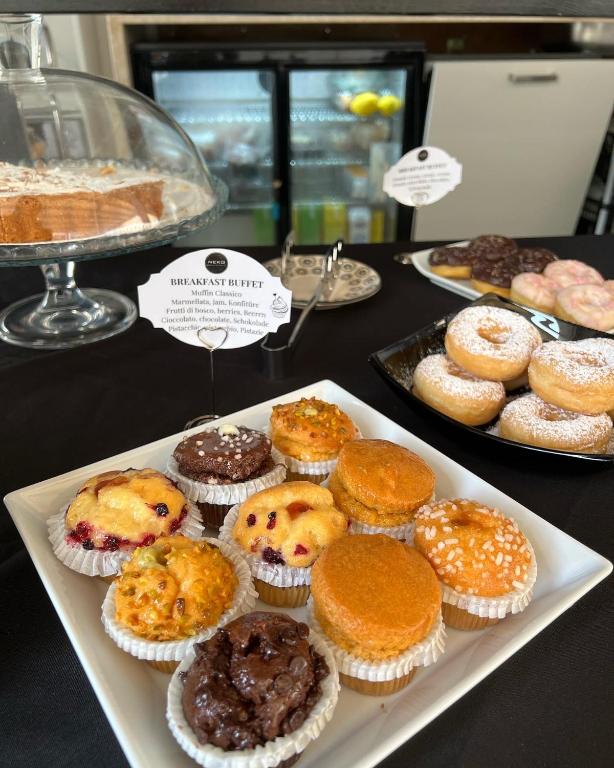 a table filled with different types of pastries and cakes at Neko Boutique Hotel in Cagliari