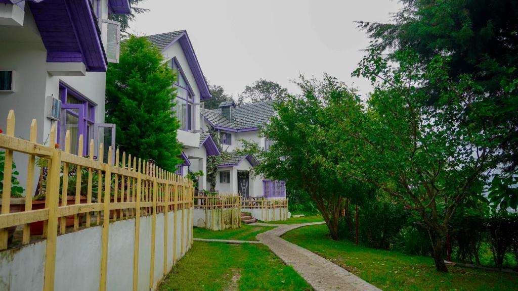 a row of purple houses with a fence at Oakwood Hamlet Resort in Shogi