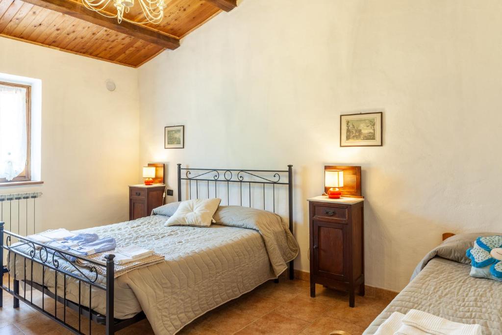 1 dormitorio con 1 cama y 2 mesitas de noche en The Dormouse - Il Ghiro, en Casola in Lunigiana