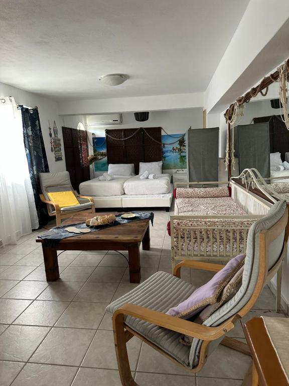 een woonkamer met een bank en een tafel en stoelen bij Galini Relax Suite in Rafina