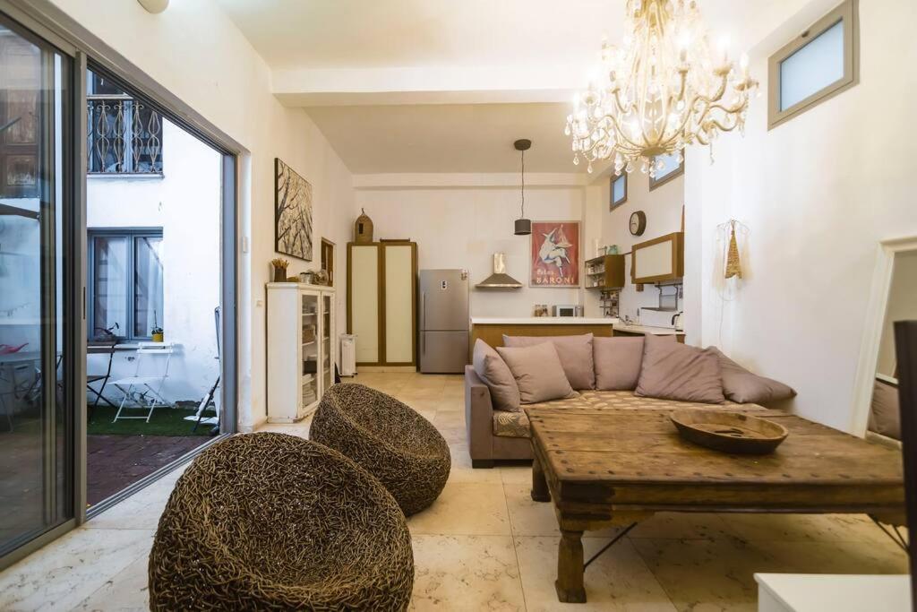 ein Wohnzimmer mit einer Couch und einem Tisch und Stühlen in der Unterkunft house with patio carmel market in Tel Aviv