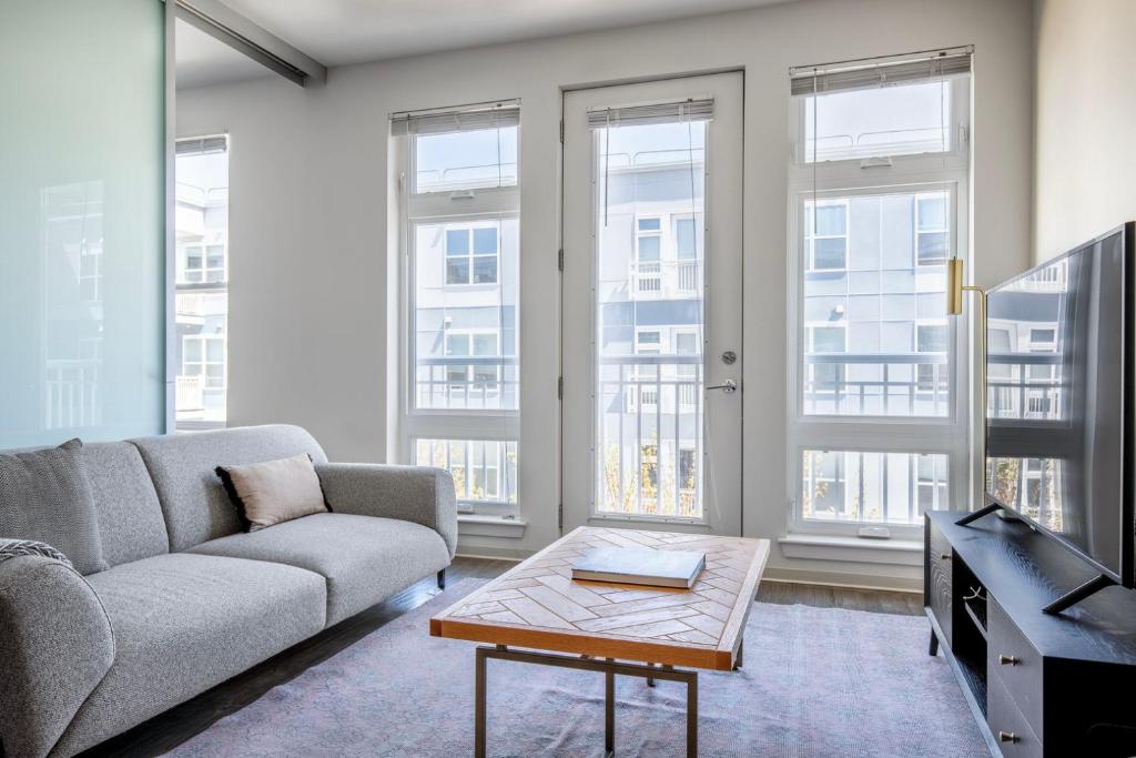 a living room with a couch and a table at Somerville 1br w wd gym roof nr Assembly T BOS-555A in Somerville