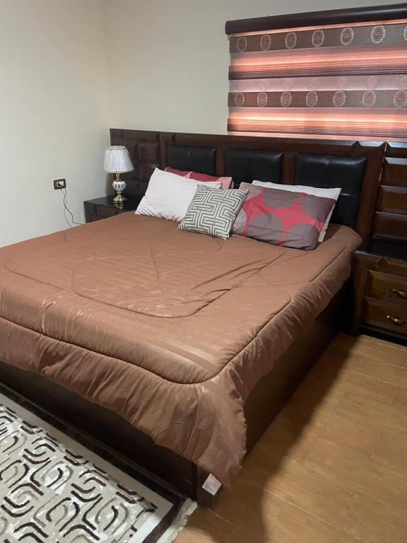 uma cama com almofadas num quarto em مزرعة النجم Najem farm em Ad Dimnah